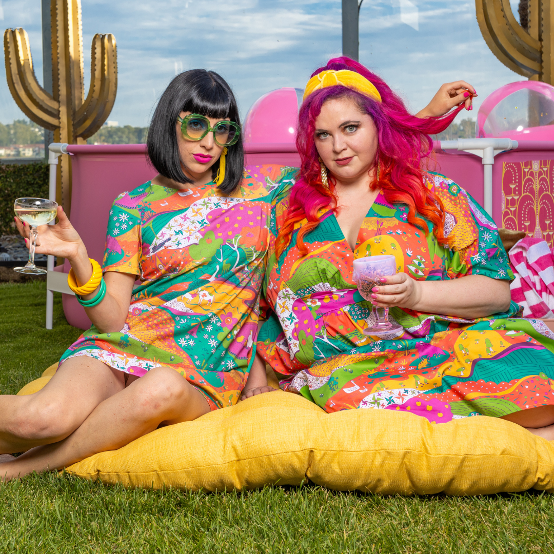 Black-haired model in colorful tunic and pink-haired model in bright caftan