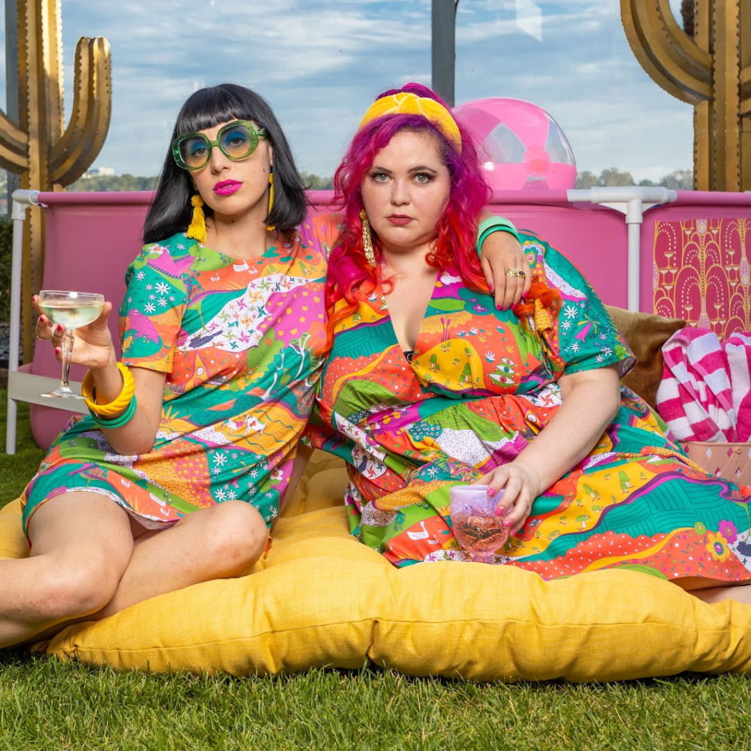 Black-haired model in colorful tunic and pink-haired model in bright caftan