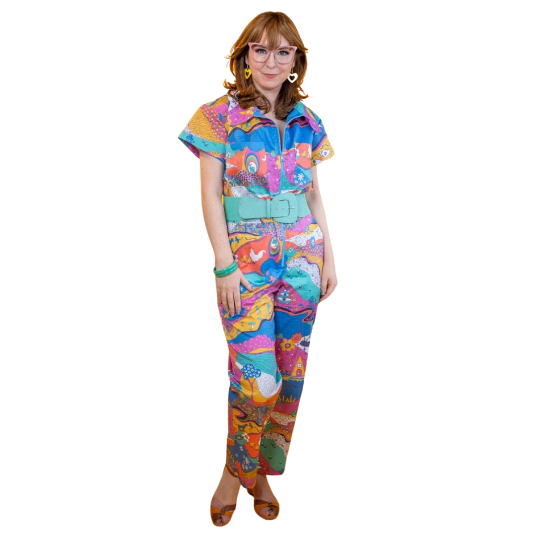 Happy model wearing sunglasses and bright colored printed jumpsuit