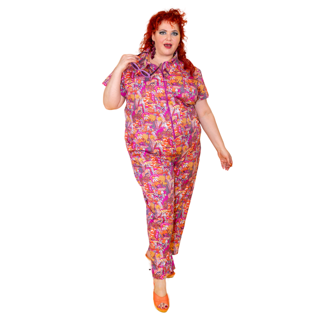 Red-haired model in bright mushroom print jumpsuit