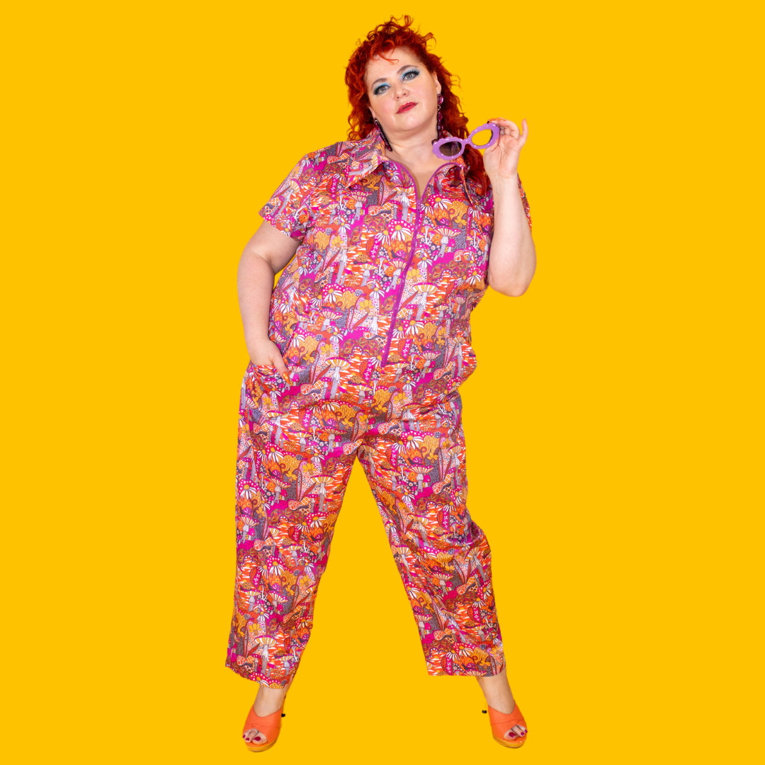 Red-haired plus sized model in mushroom print jumpsuit