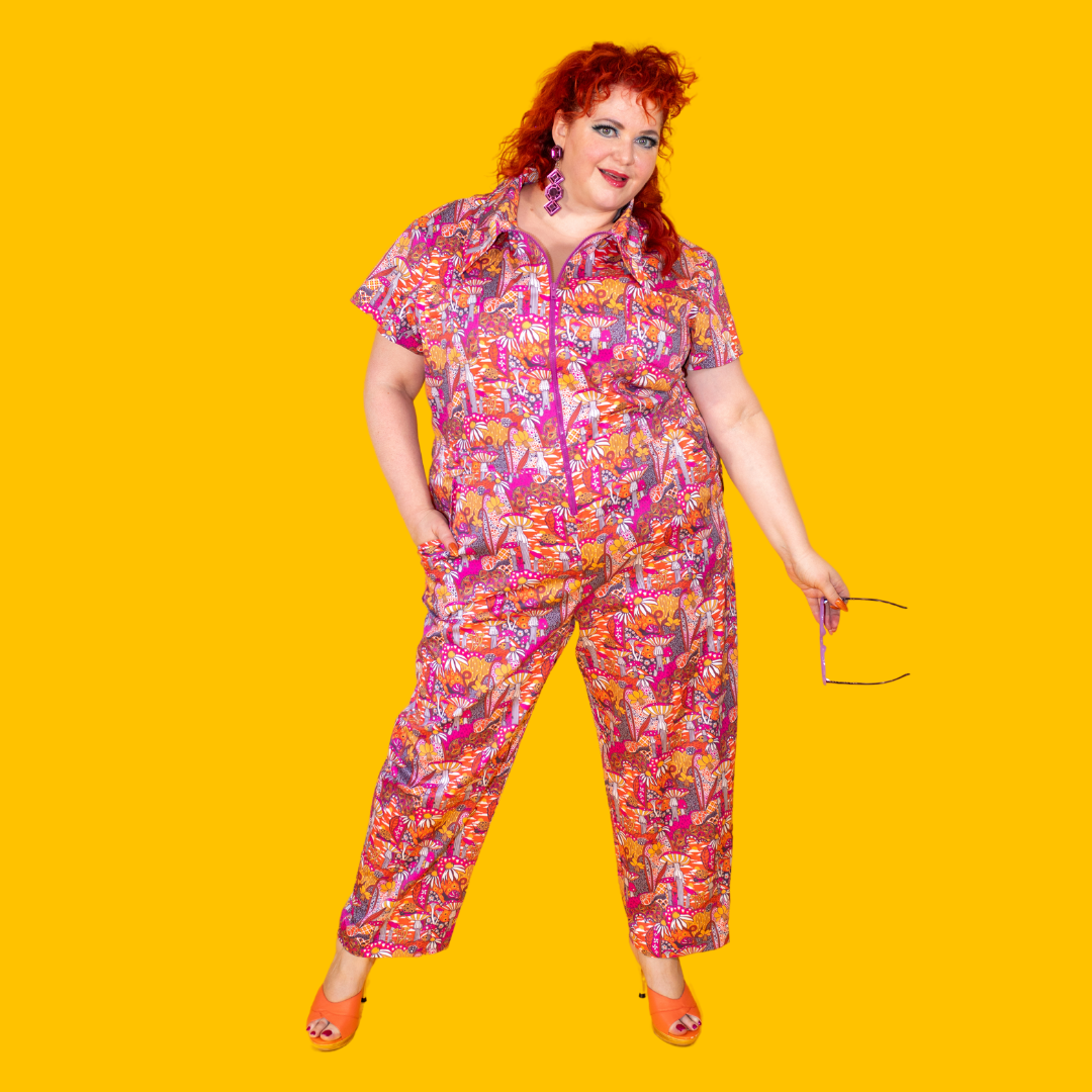 Red-haired model in mushroom print jumpsuit in warm tones