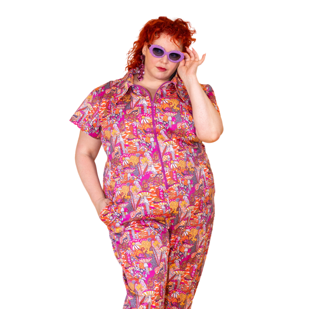 Closeup of red-haired model in mushroom print jumpsuit
