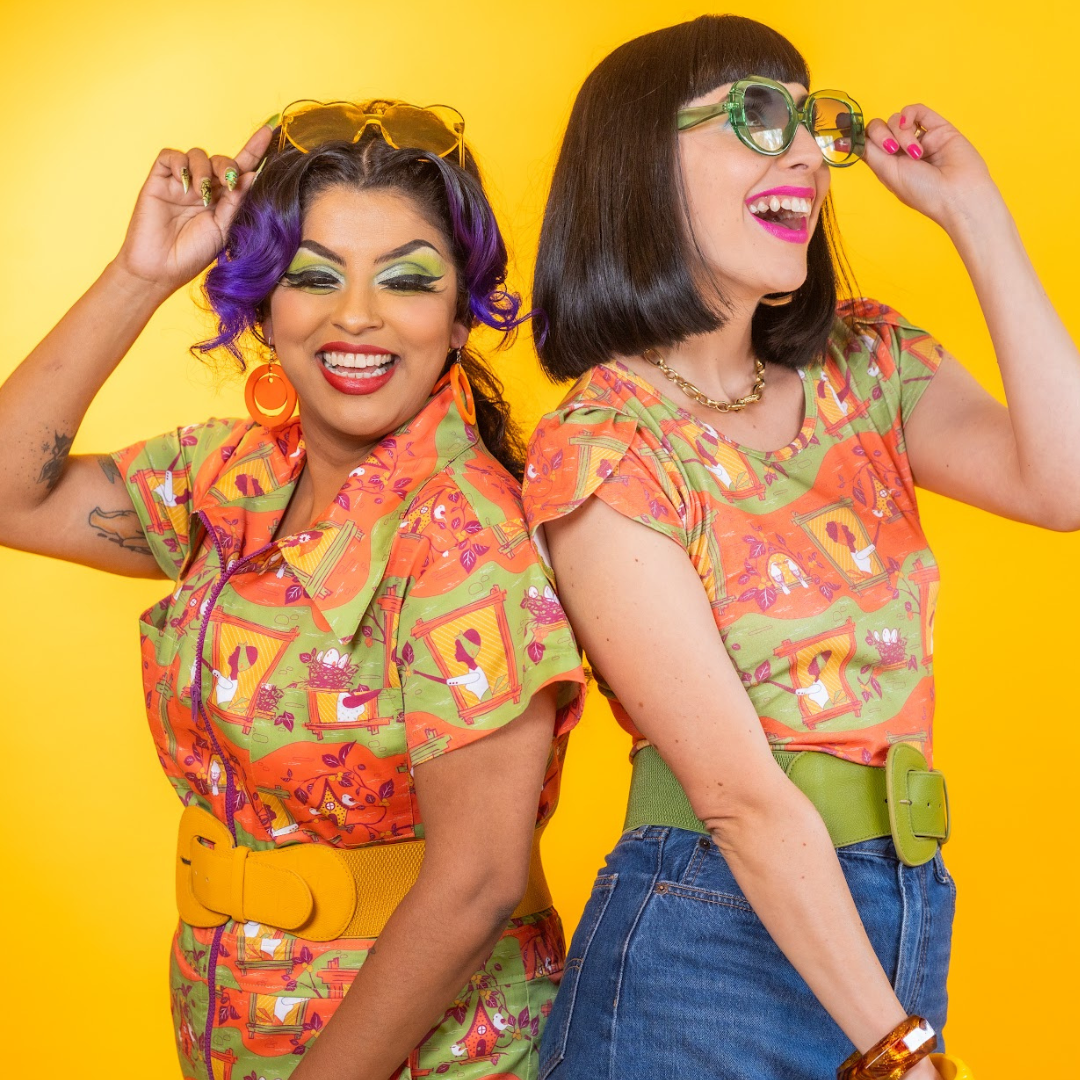 Two laughing models wearing fun orange and green styled outfits