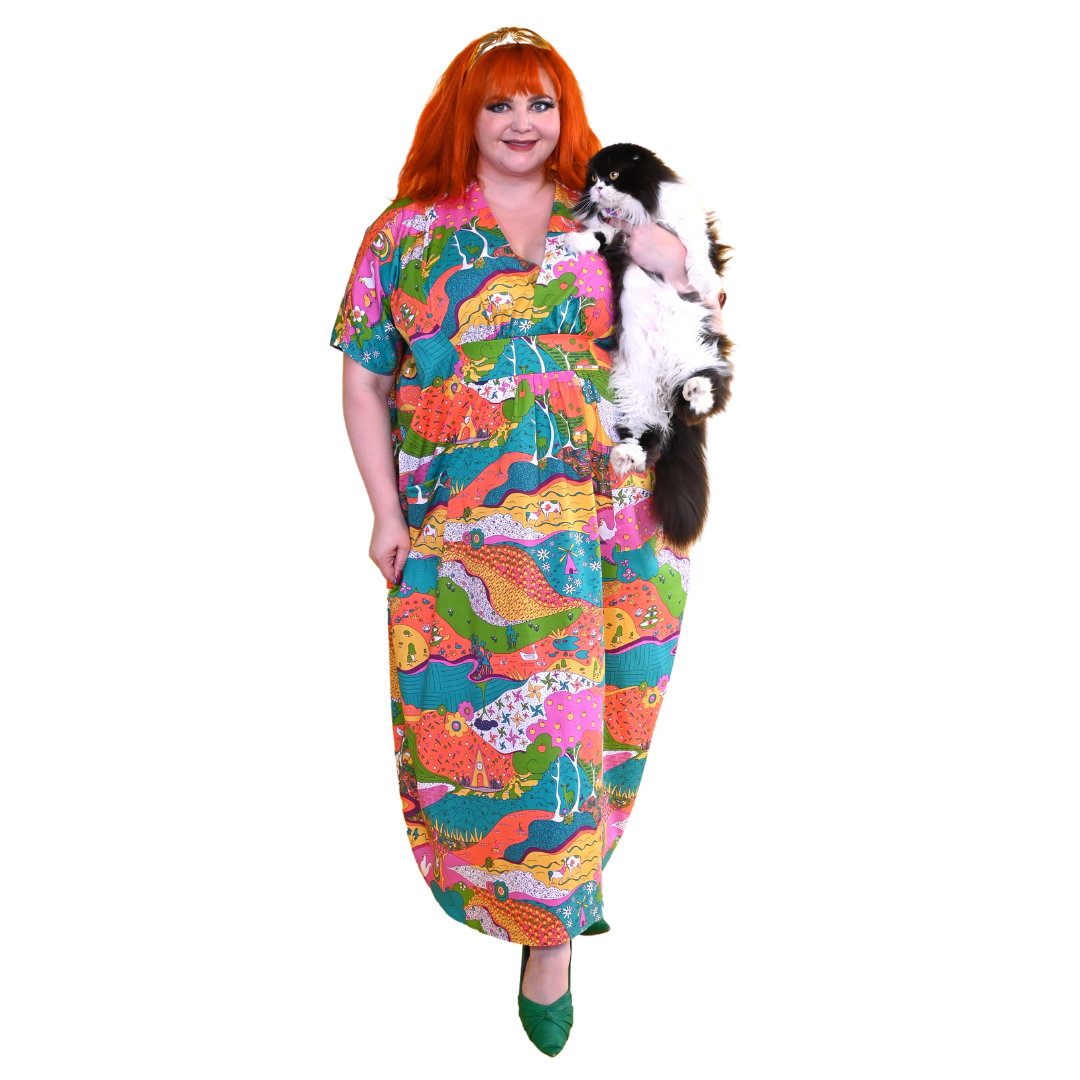 Red-haired model in bright caftan dress & holding cat