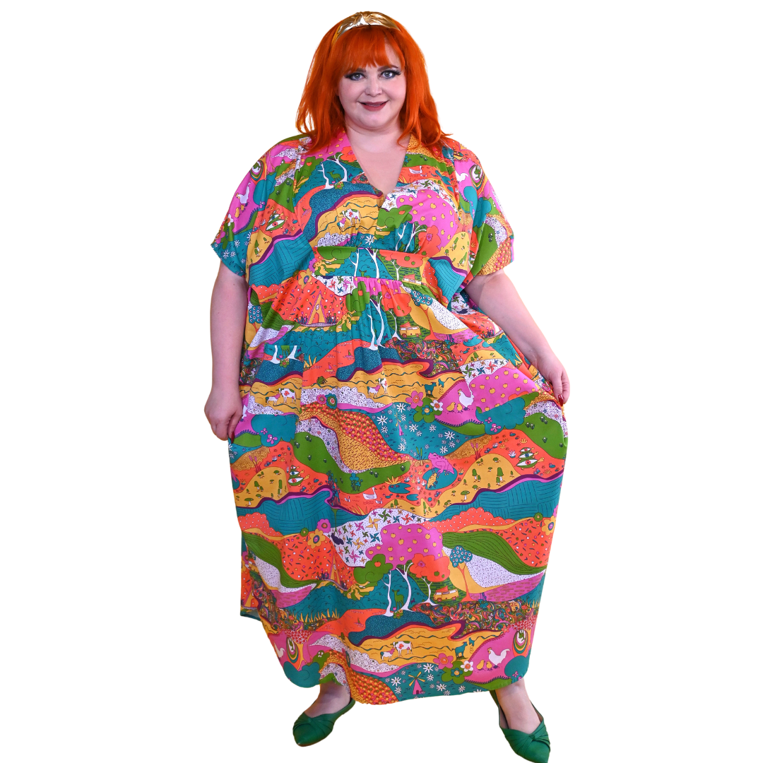 Red-haired model in bright, colorful printed caftan dress