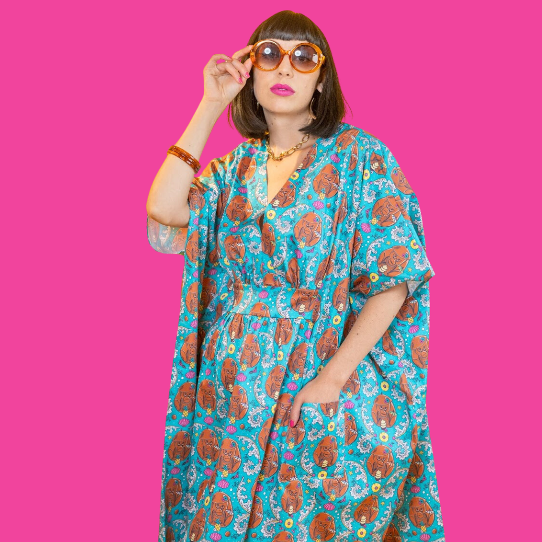 Dark haired model in sunglasses and teal coconut monkey midi caftan