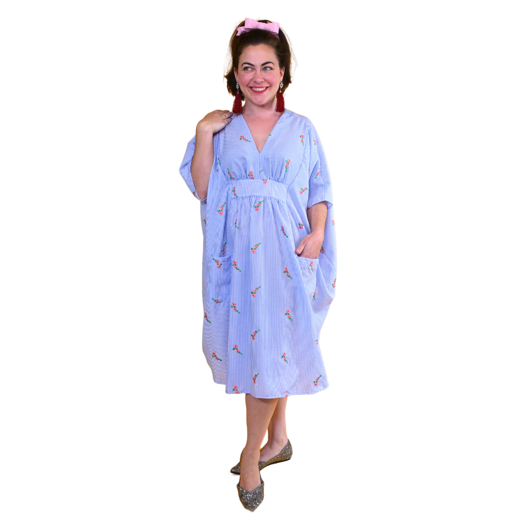 Model in blue and white embroidered seersucker caftan with patch pockets