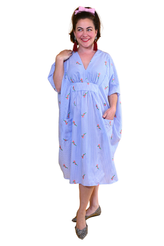 Cute model in blue and white seersucker caftan with embroidered flowers