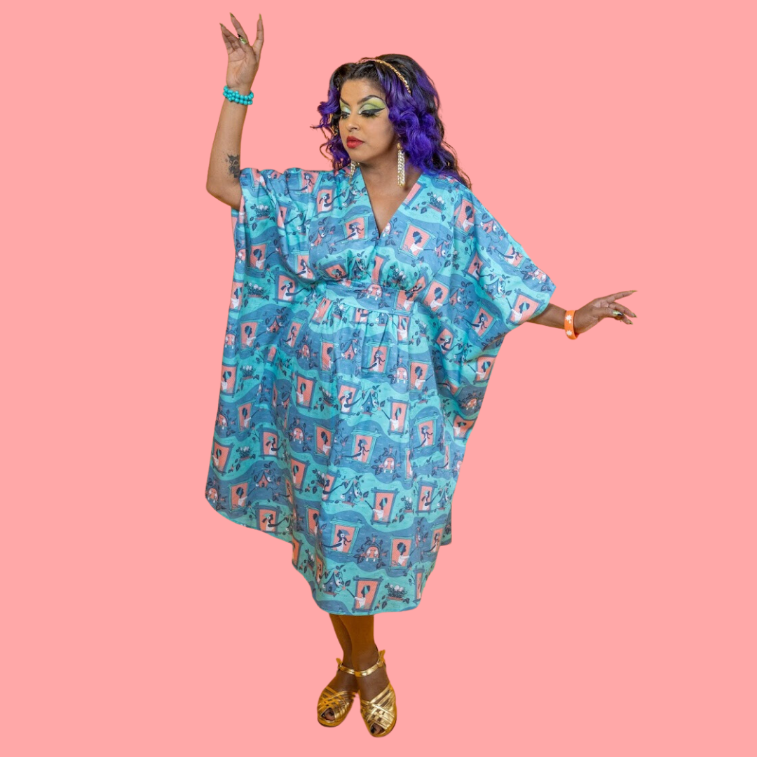 Full body view of model in peach, mint and grey caftan with girls feeding birds