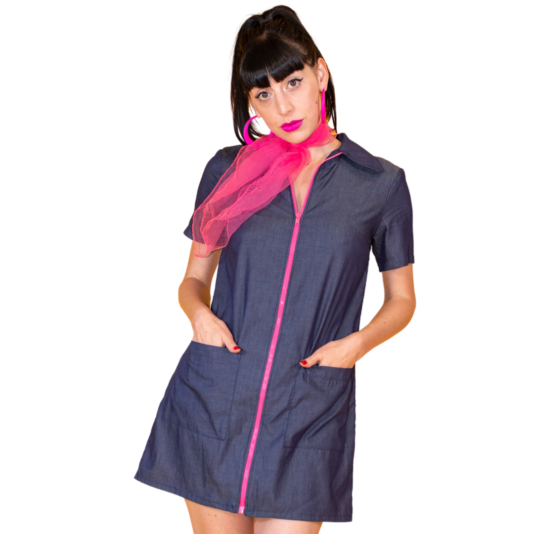 Closeup of dark-haired model in dark denim minidress with pink zip and cute pink accessories