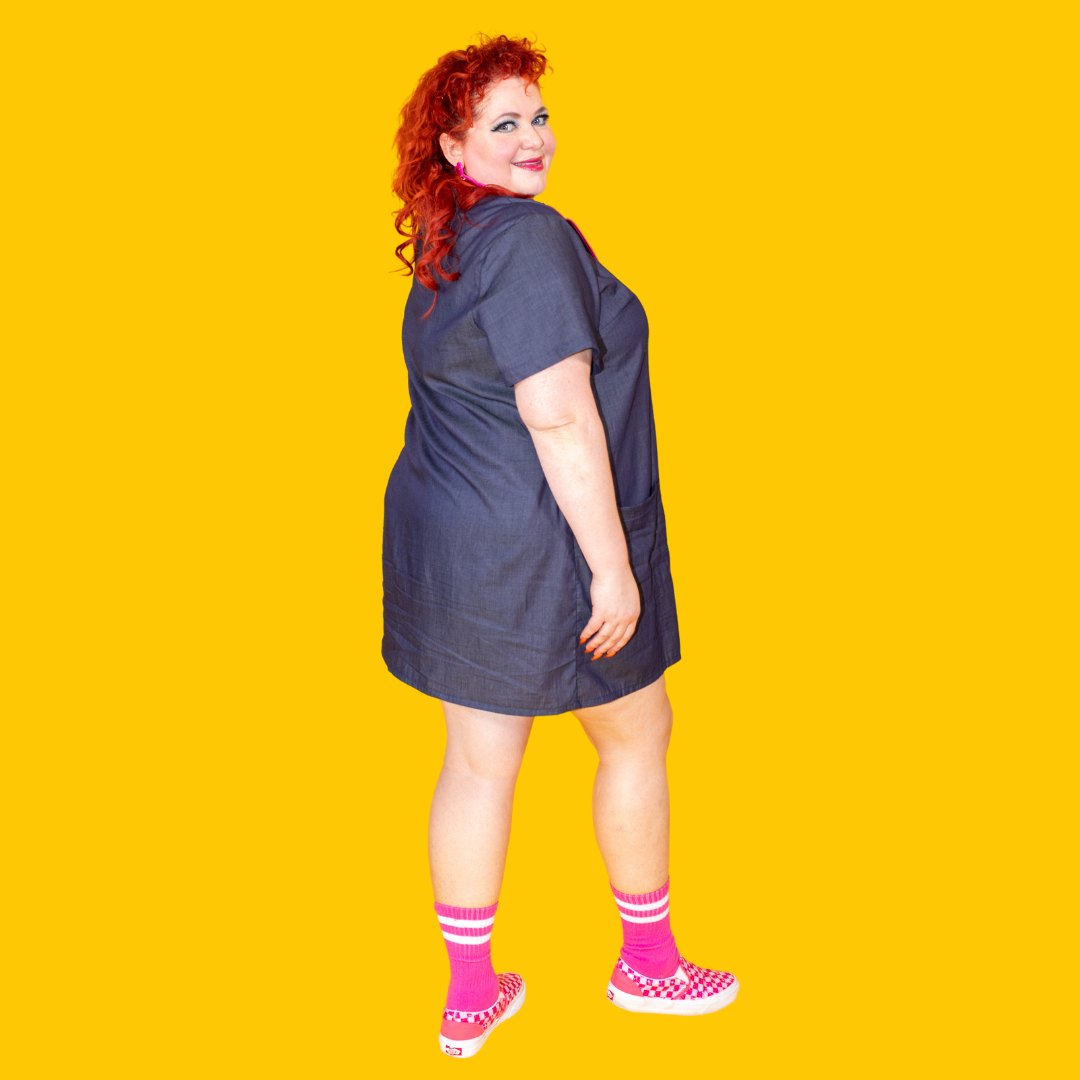 Side view of dark denim minidress on lively red-haired model