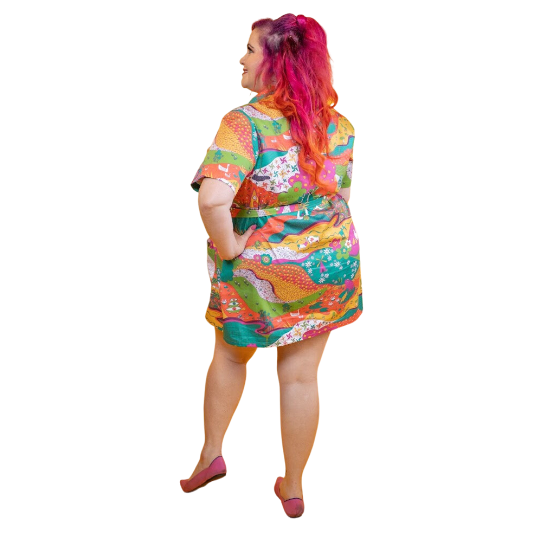 Back view of pink-haired model in brightly colored printed belted minidress