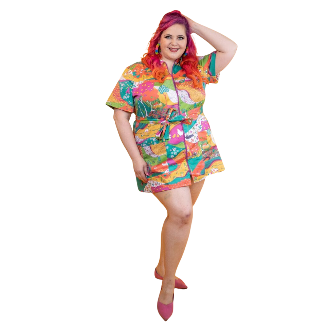 Pink-haired model in brightly colored printed belted minidress