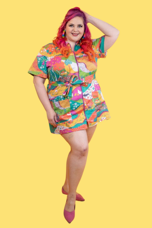 Pink-haired model in brightly colored printed belted minidress