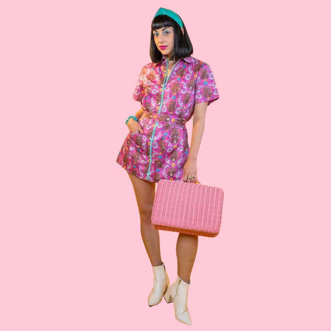 Cute black-haired model in pink dress with tiki monkey print