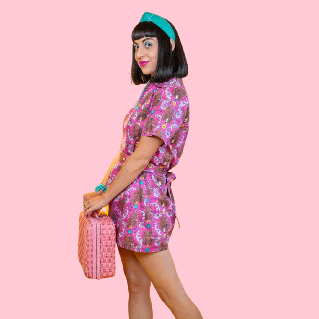 Model wearing pink belted minidress and wicker bag