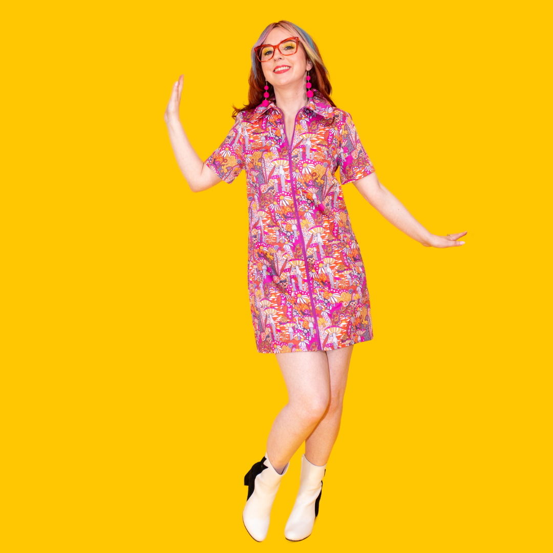 Model in classes and bright colored zip-front minidress