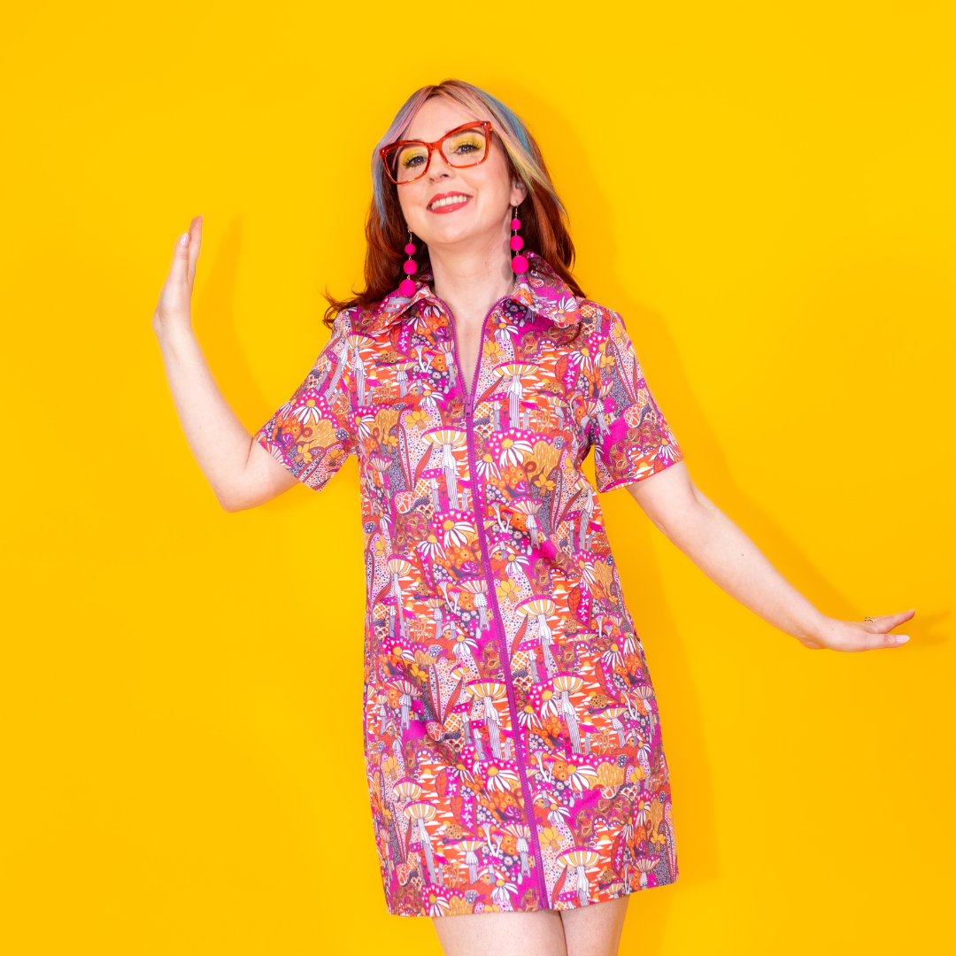 Closeup of small model in mushroom print zip-front minidress