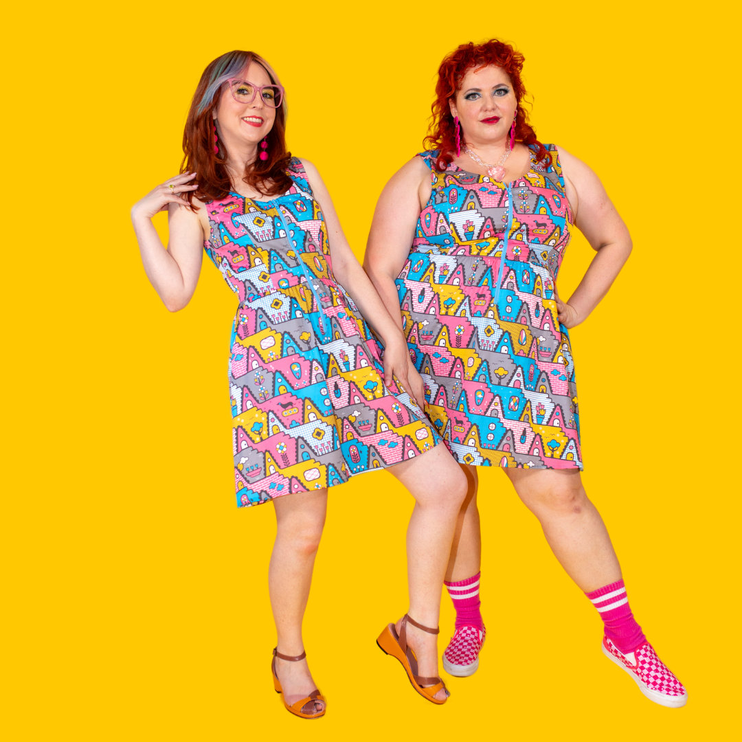 2 darling models wearing zip-front fit and flare dresses in a fun geo print