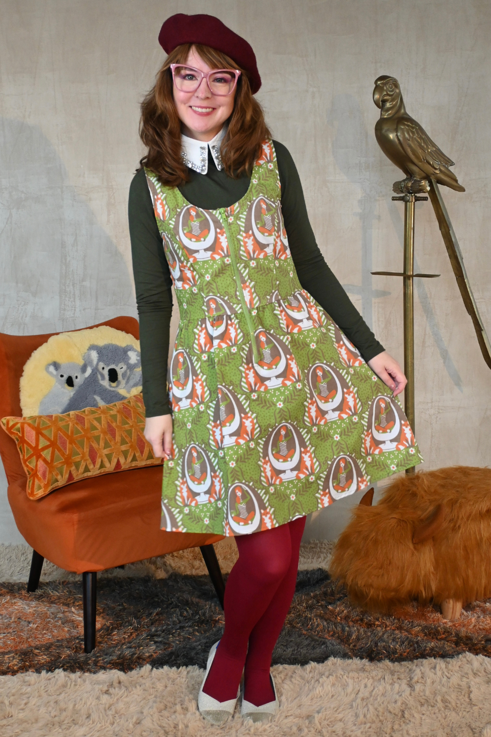 Cute girl wearing beret and green cotton zip-front dress accessorized with beret,  sweater, collar, and tights