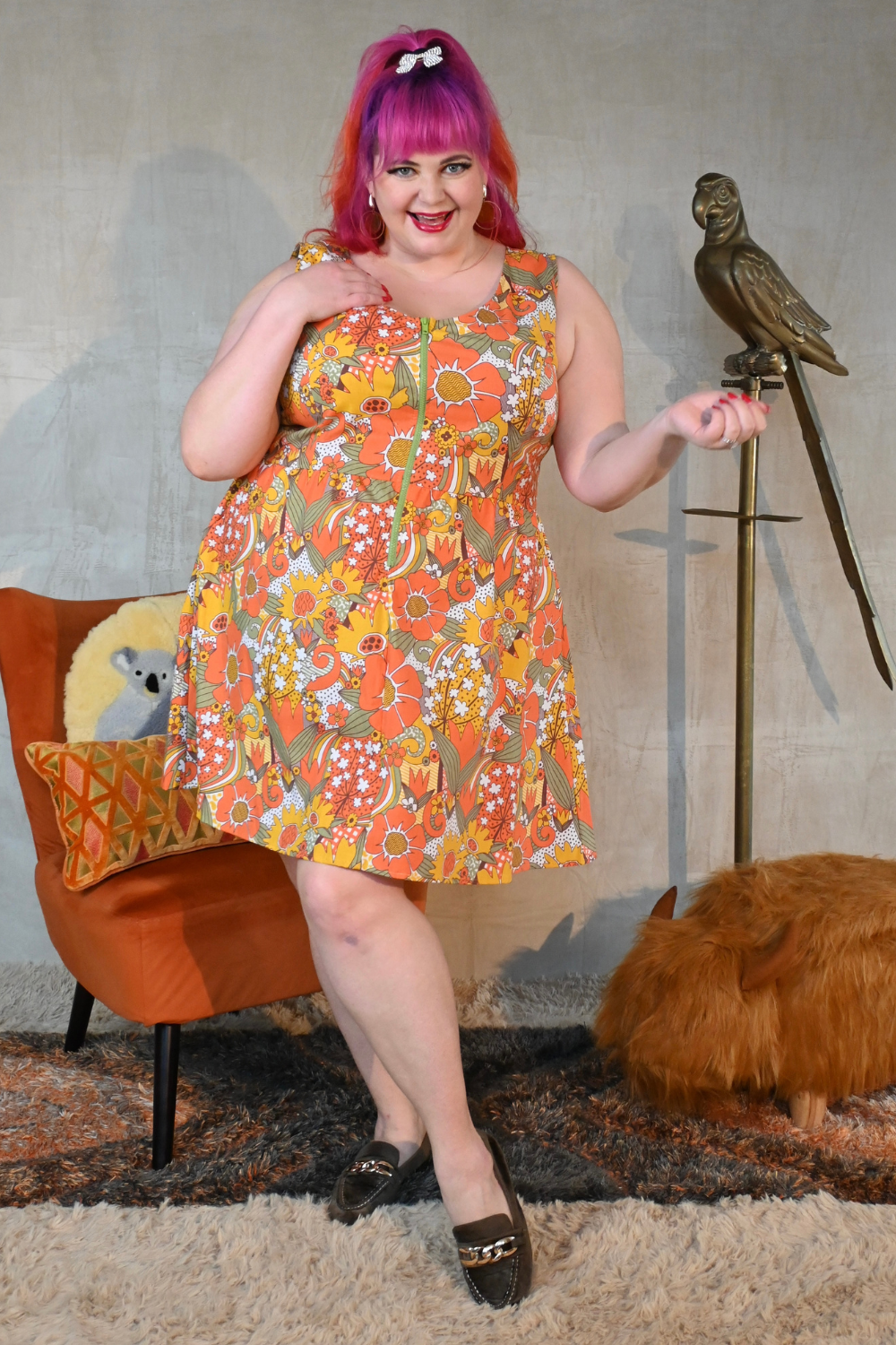Pink-haired curvy model wearing sleeveless cotton floral zip-front knee-length dress
