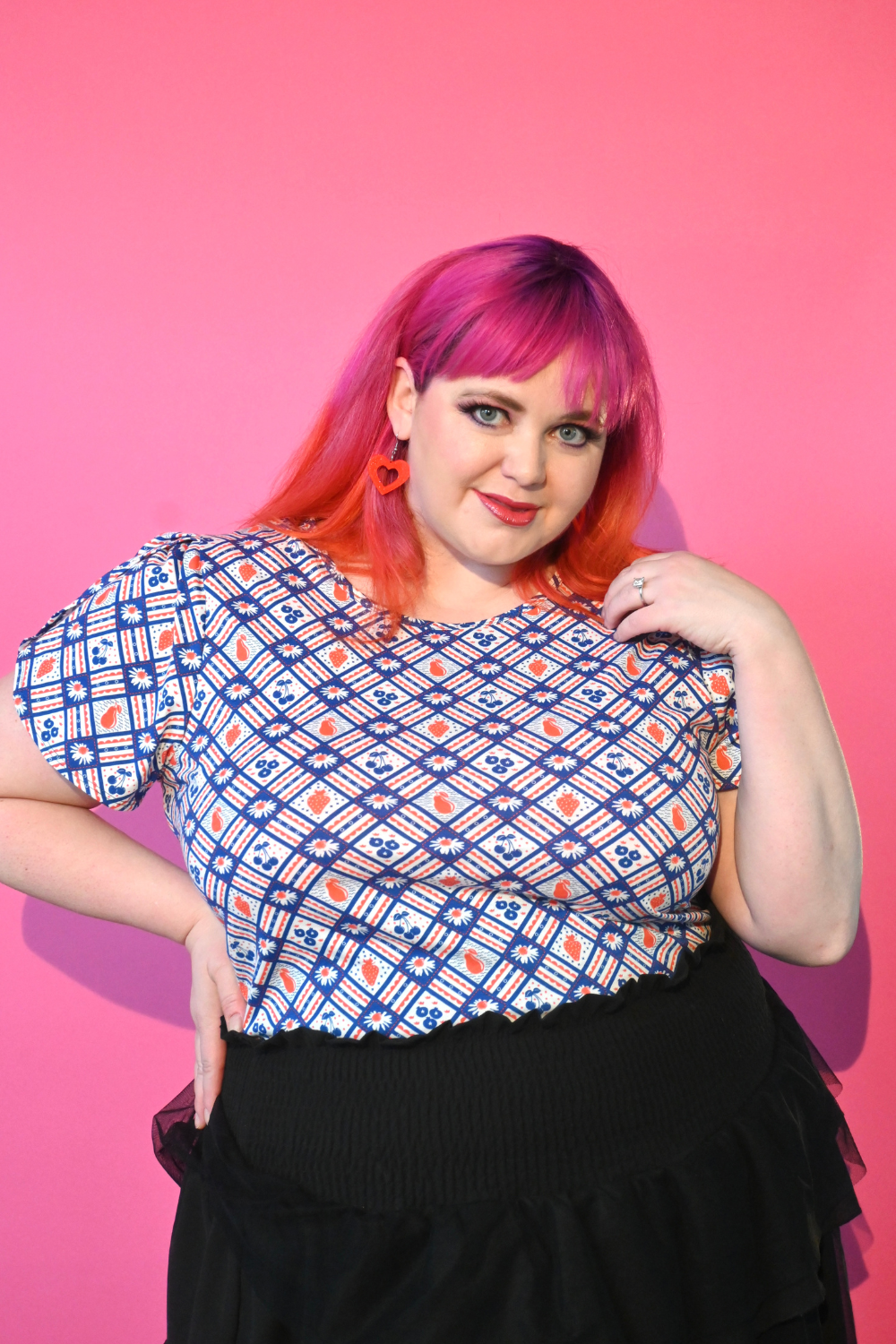 Pink-haired model in red and navy fruit and gingham print tee
