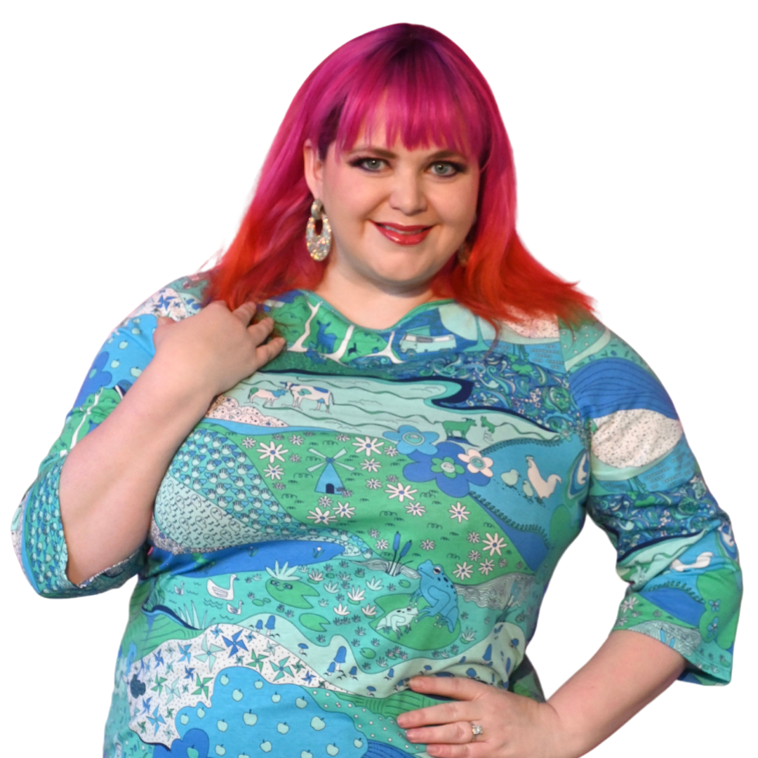 Closeup of pink-haired girl wearing blue green landscape print graphic tee