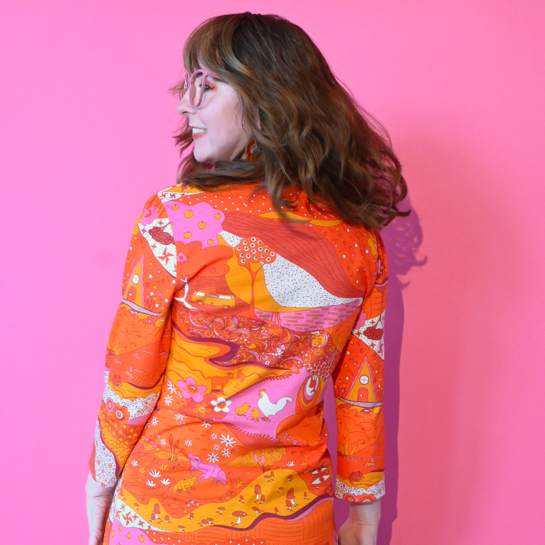 Back view of landscape print graphic tee in hot colors