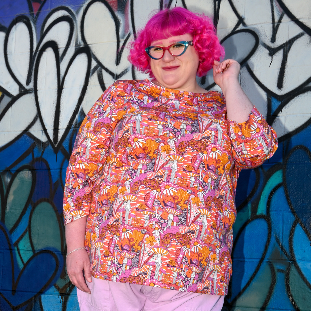 Pink-haired model in mushroom print 3/4 sleeve tee, closeup