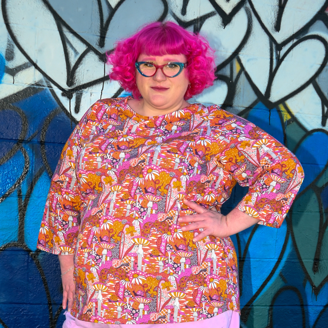 Closeup of pink-haired model in mushroom print tee