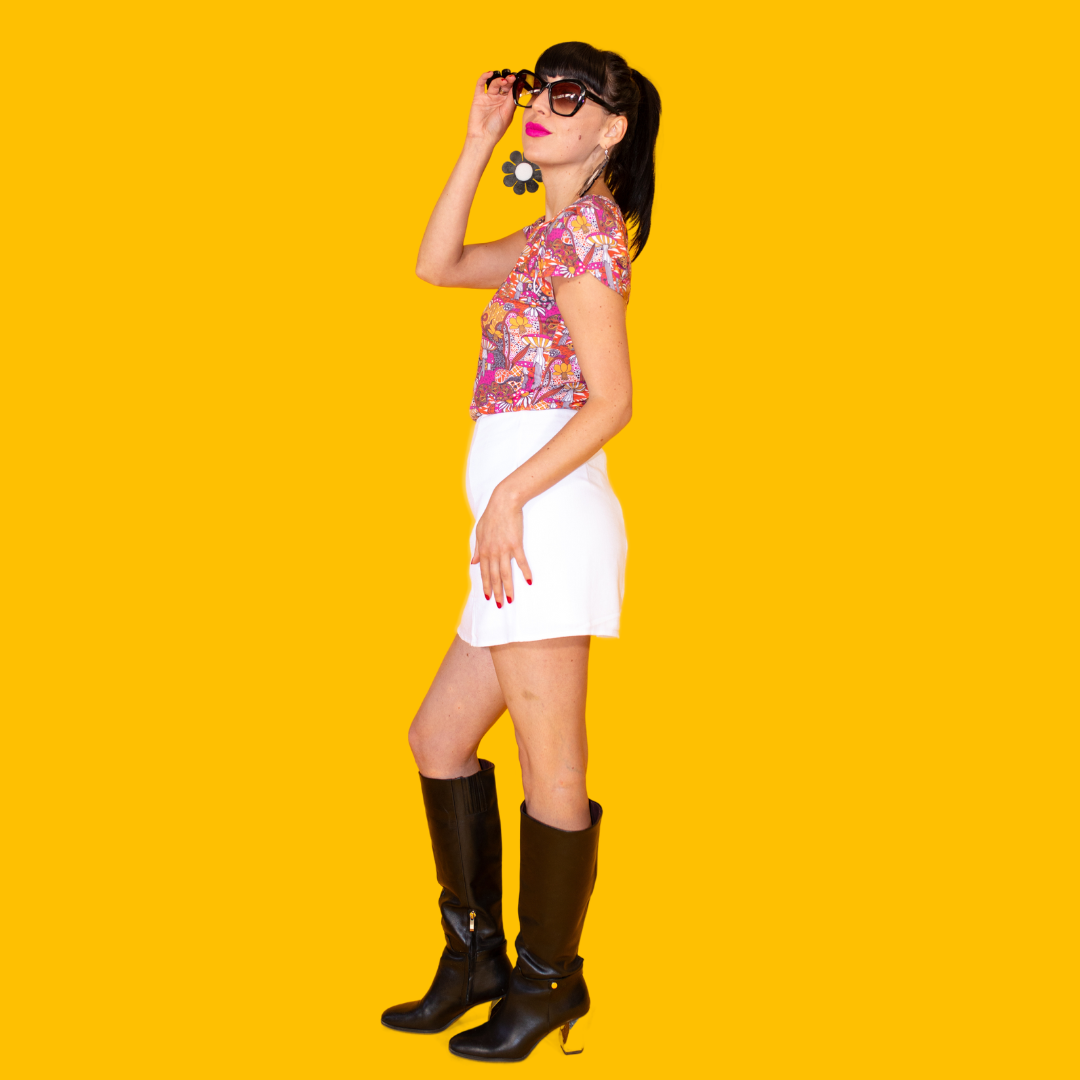 Side view of dark-haired model in tee, miniskirt and boots