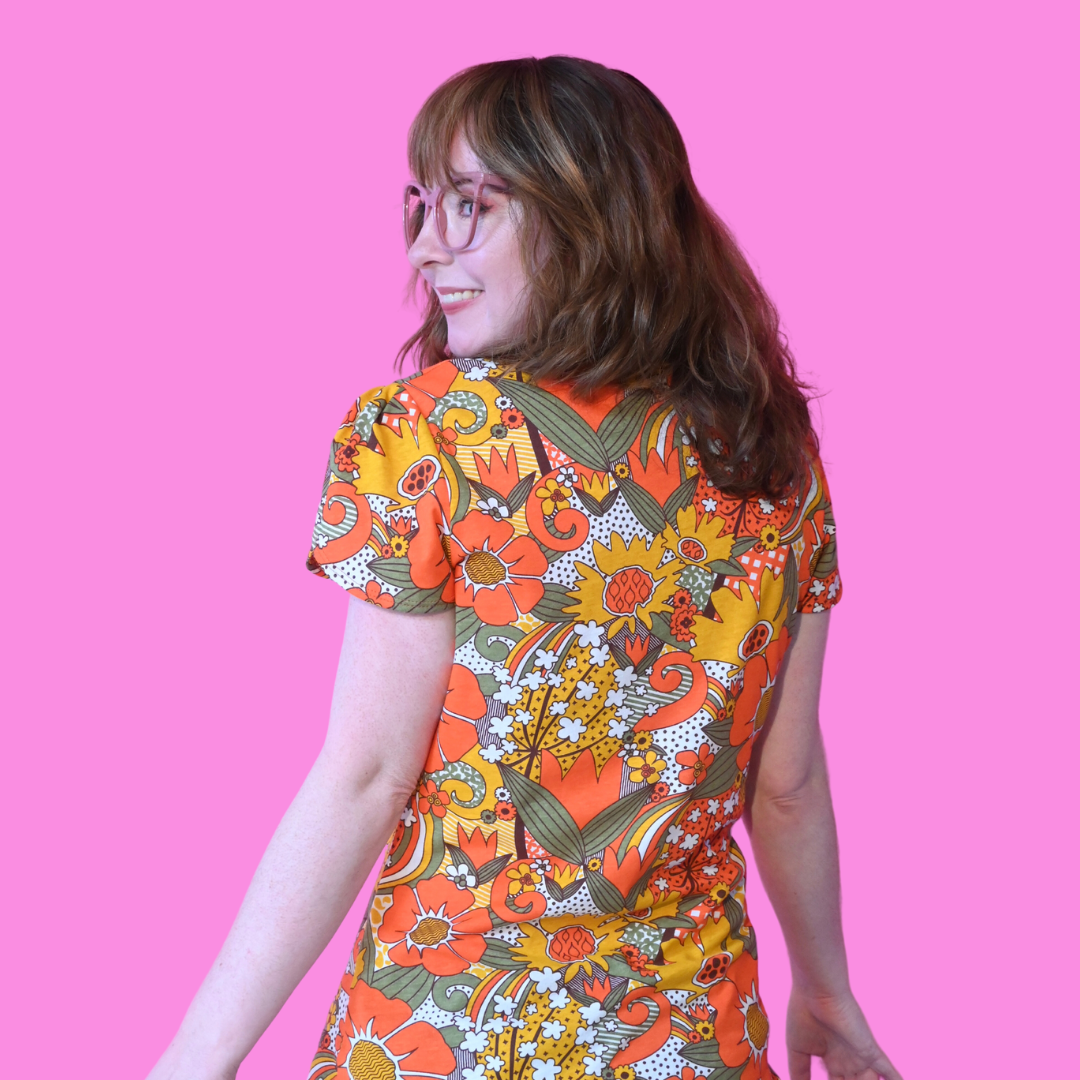 Back view of brown-haired model in short-sleeved floral print tee