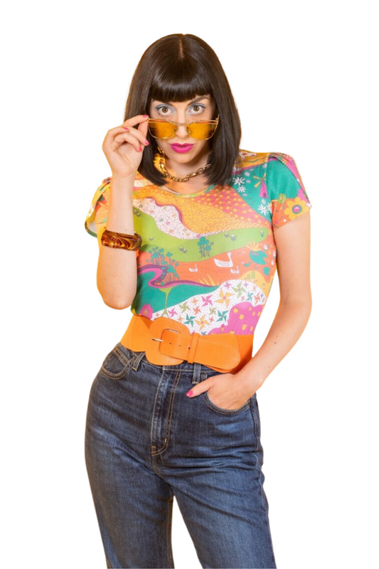 Black-haired model in bright, colorful printed tee, belt and jeans