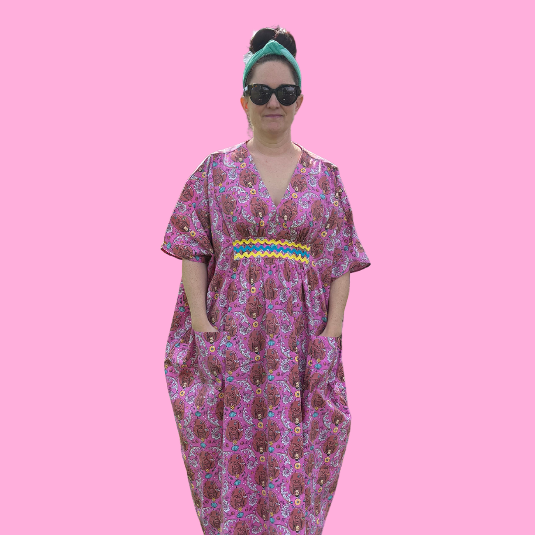 Woman with sunglasses in pink monkey print caftan with ricrac trim