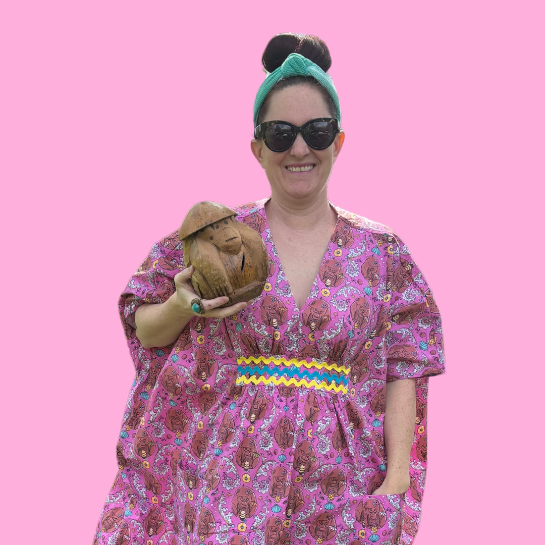 Woman with sunglasses in pink monkey print caftan with ricrac trim & coconut monkey