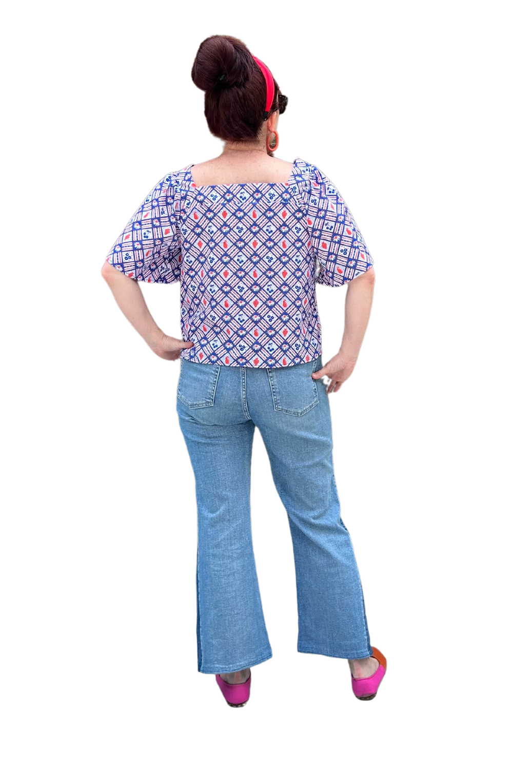 Back of square neck peasant top with blue and red print and graphic of fruit and flowers