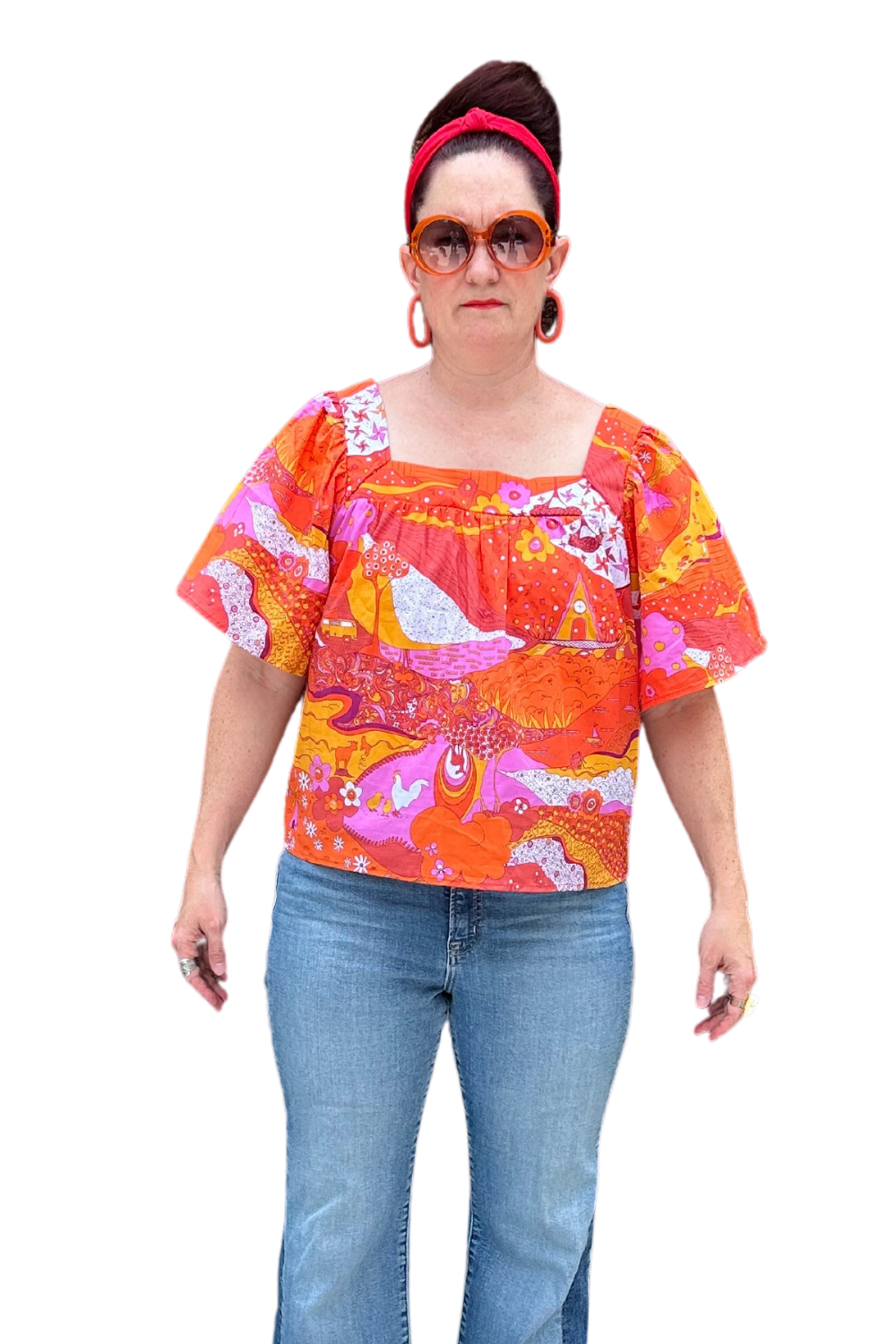 Model in brightly colored woven square-neck top with landscape print in pink, orange and yellow