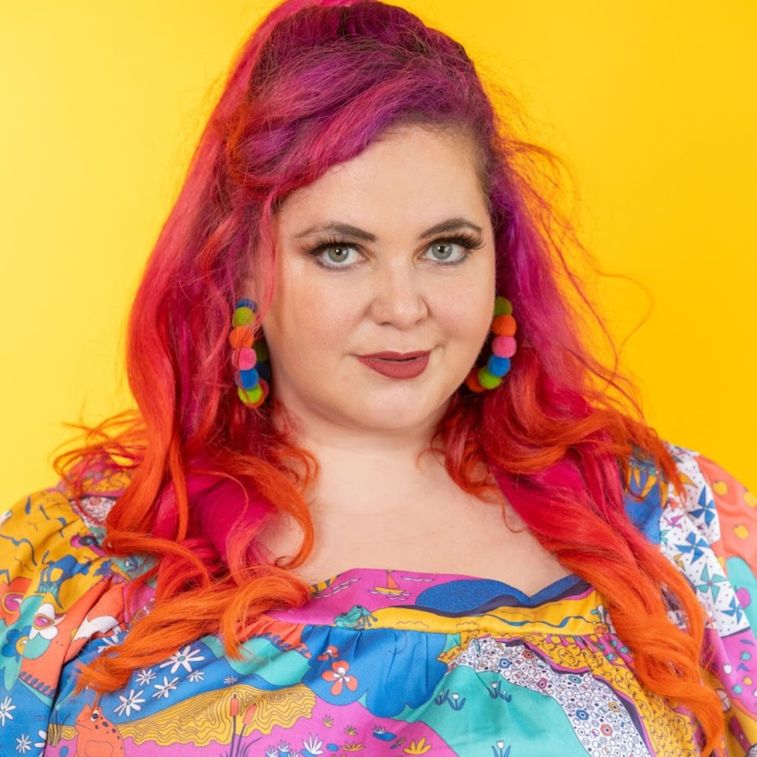 Closeup of pink-haired model in vintage inspired landscape print top