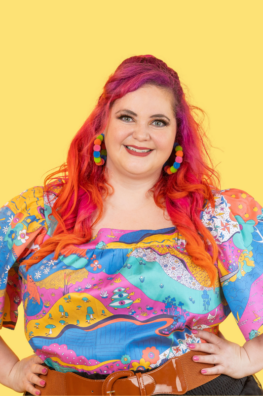 Pink-haired model in multicolored printed shirt with animals