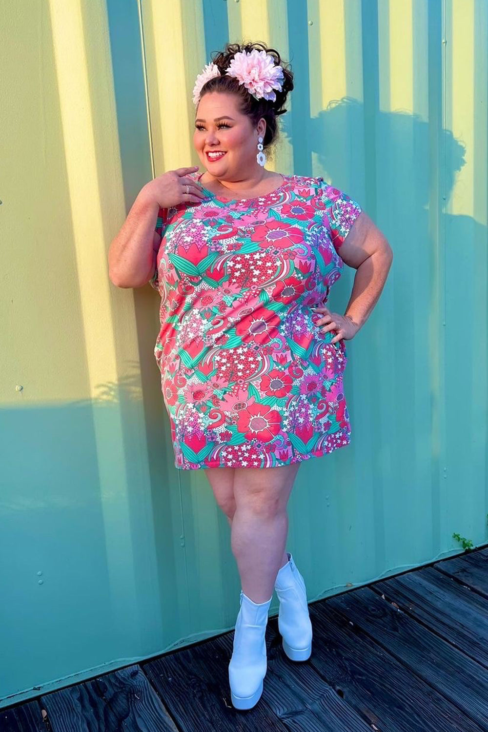 Model wearing tunic with magenta flowers and teal accents