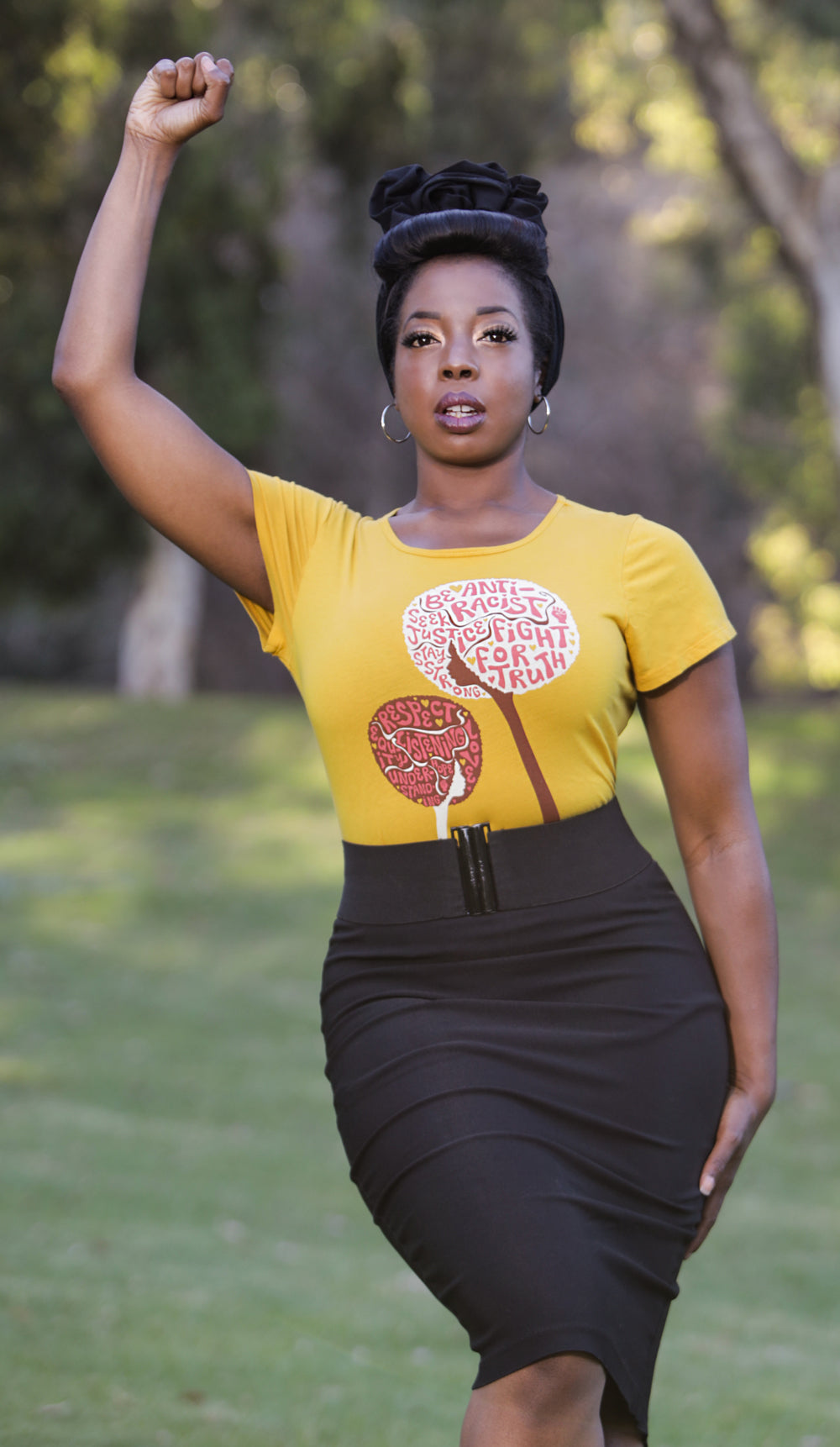 Yellow womens tee featuring afro flowers with anti racist messages on strong Black model
