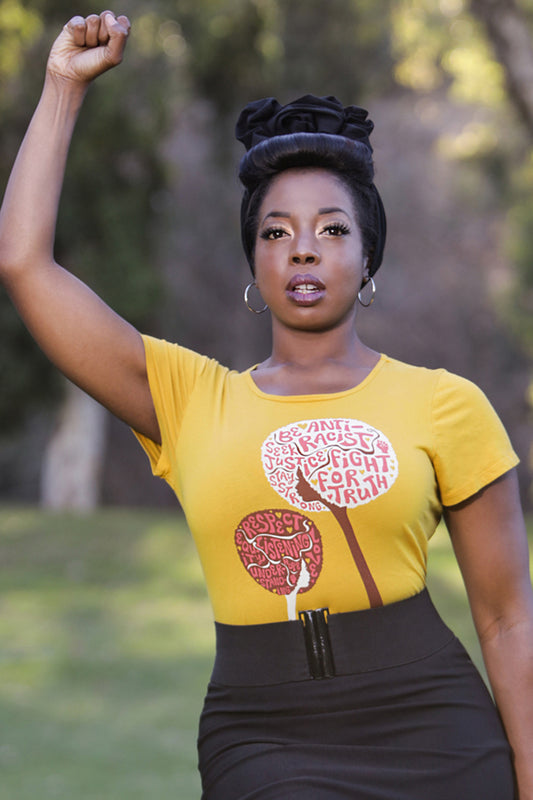 Yellow womens tee featuring afro flowers with anti racist messages on strong Black model