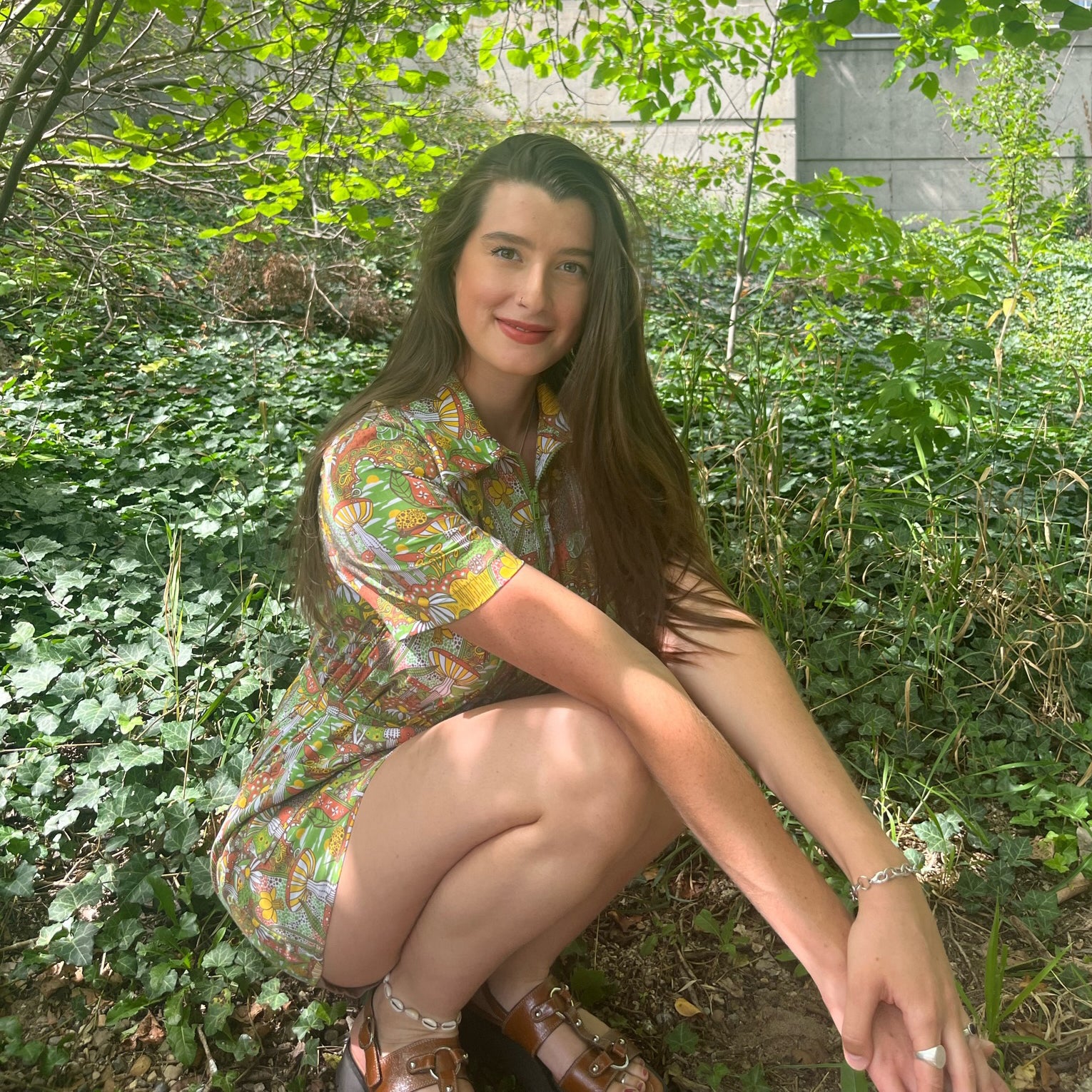 Dark-haired model in olive green, rust and mustard belted zip-front collared minidress