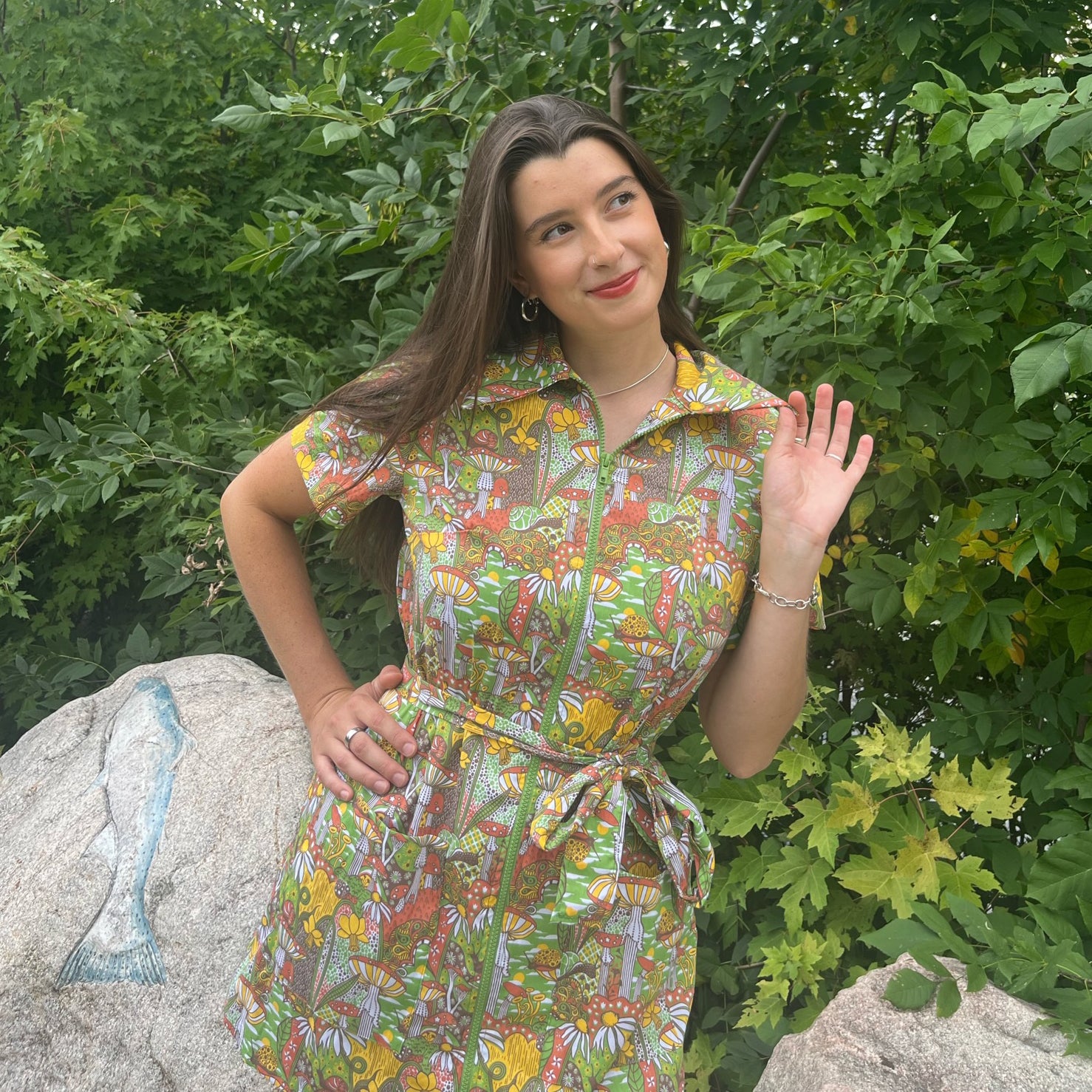 Dark-haired model in olive green, rust and mustard belted zip-front collared minidress