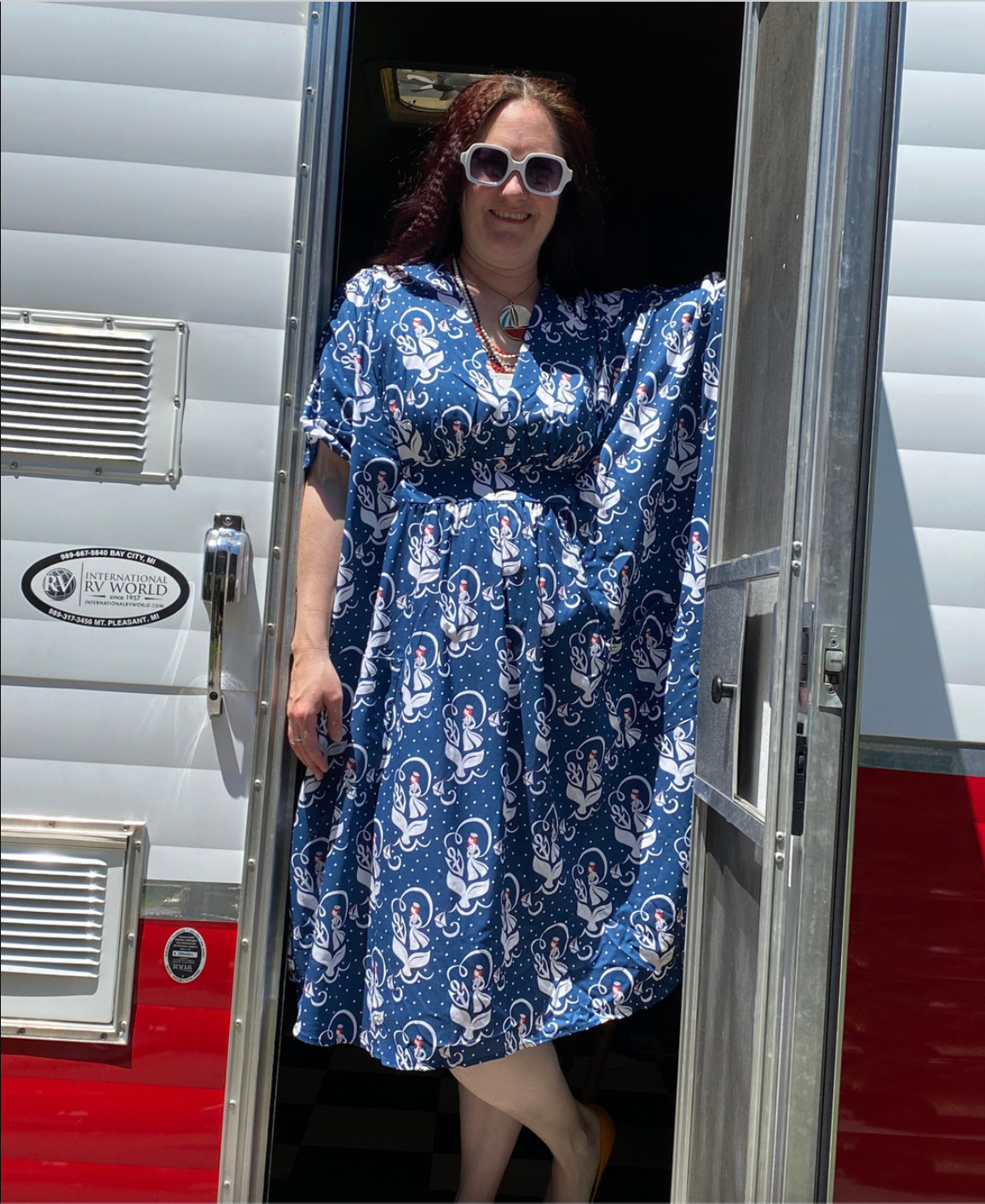 Woman in sunglasses and navy, red, and white v-neck nautical pocket midi caftan