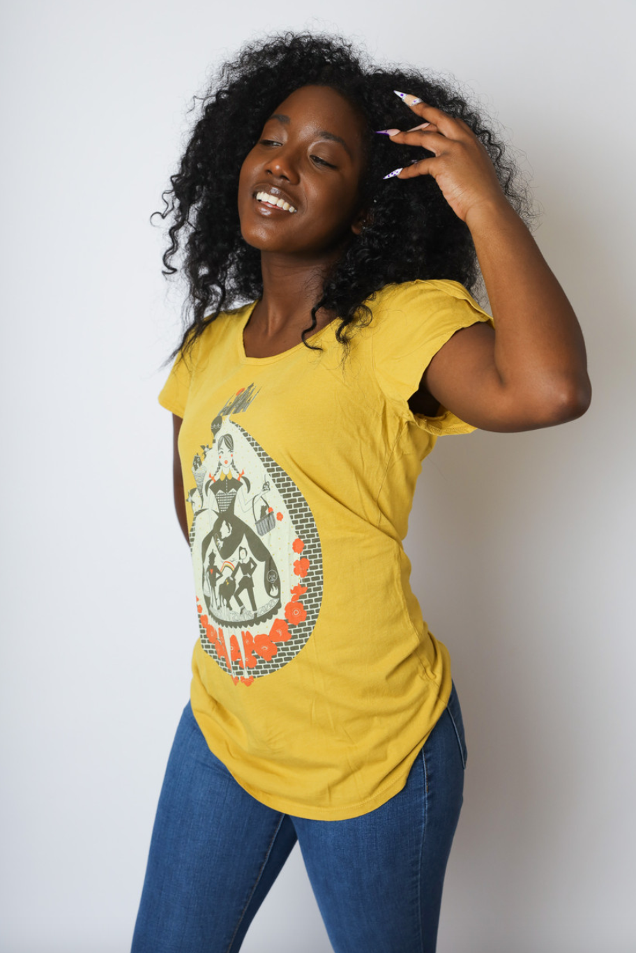 Yellow tulip sleeve Wizard of Oz inspired graphic tee with Dorothy, poppies, dog, scarecrow on curly haired model