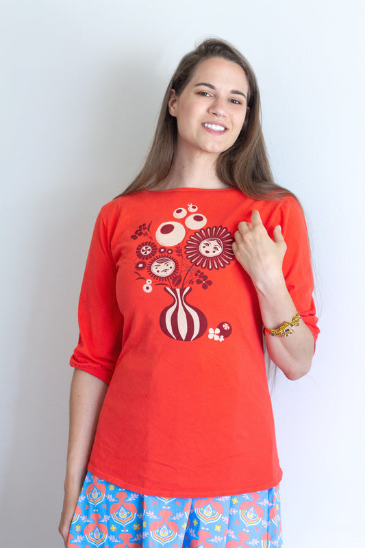 Bright orange boatneck tee with vintage flower vase print in brown and white