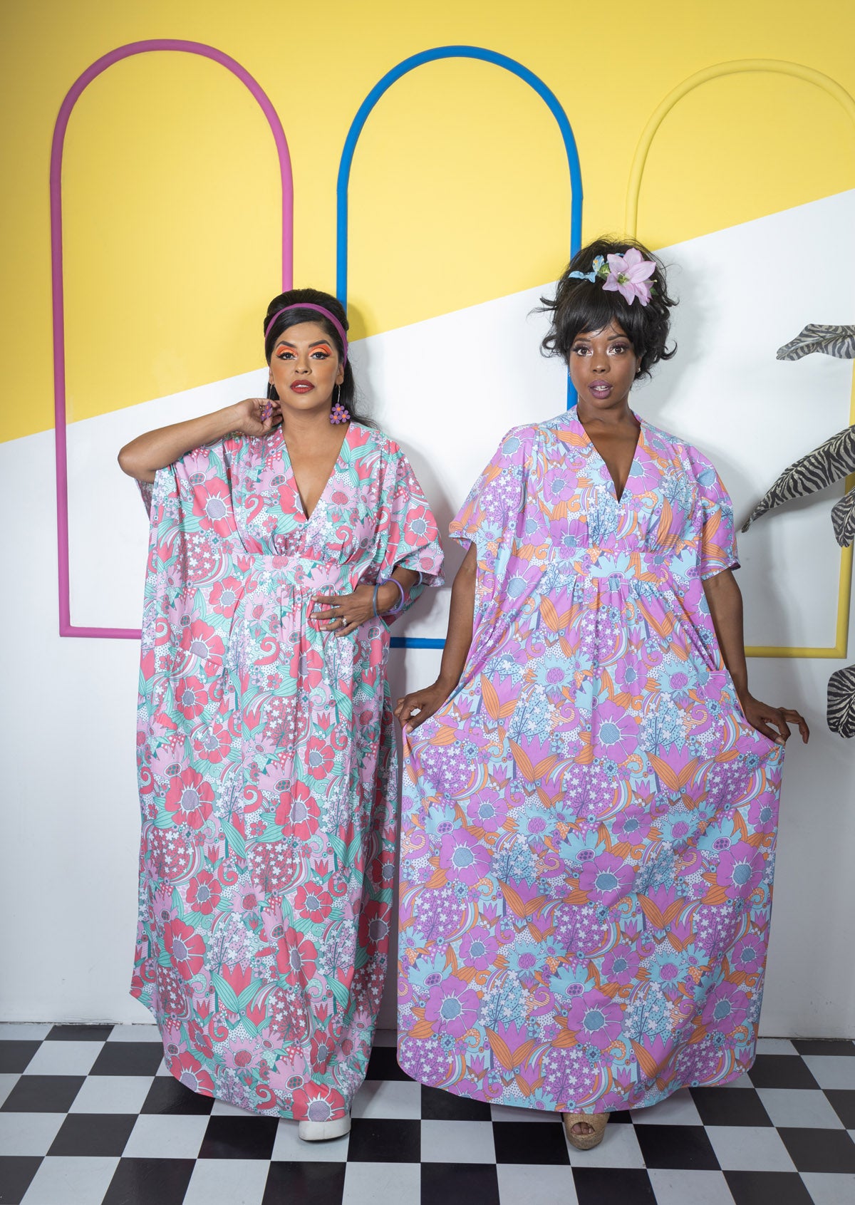 2 women posing in flower print dresses