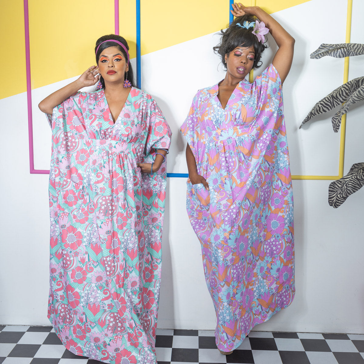 2 women in long, colorful floral beach dresses